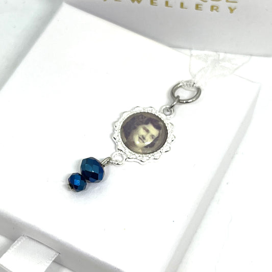 Photo set in a silver setting with blue glass beads 