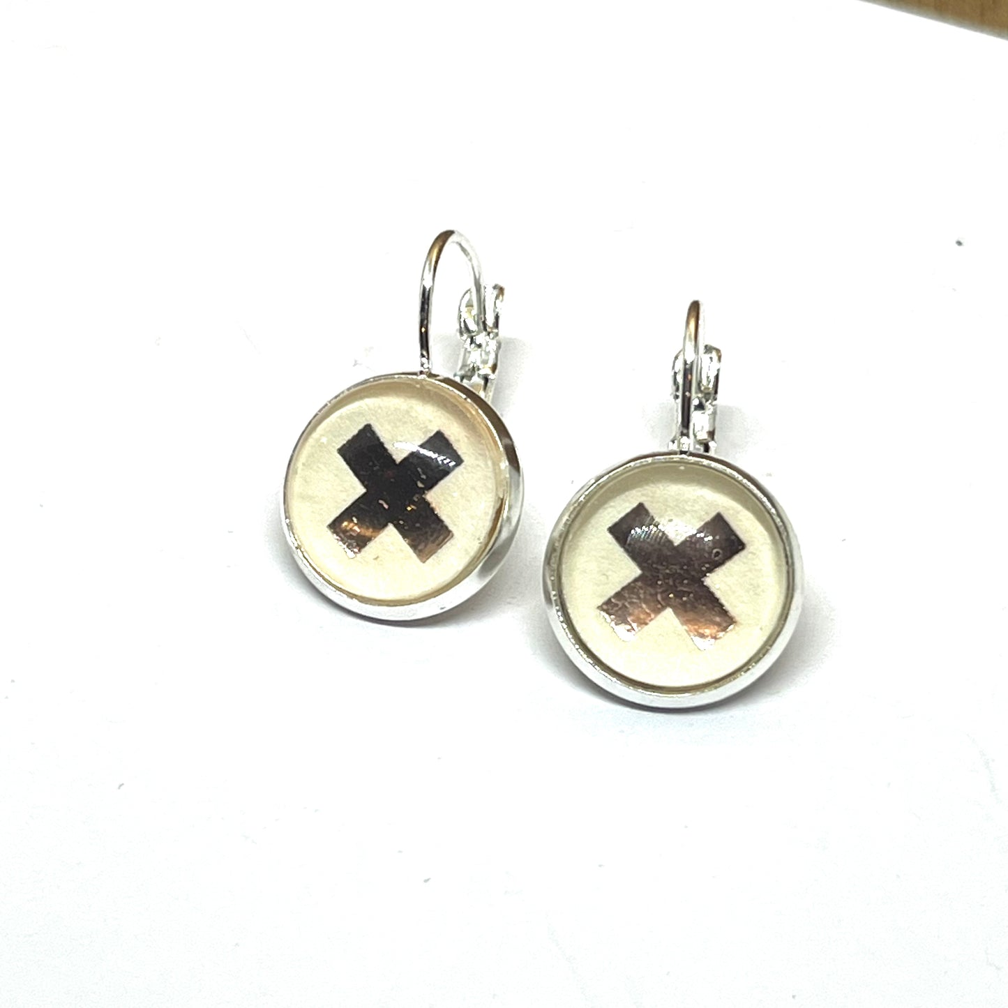 Stylish Rose gold kiss earrings on a cream background