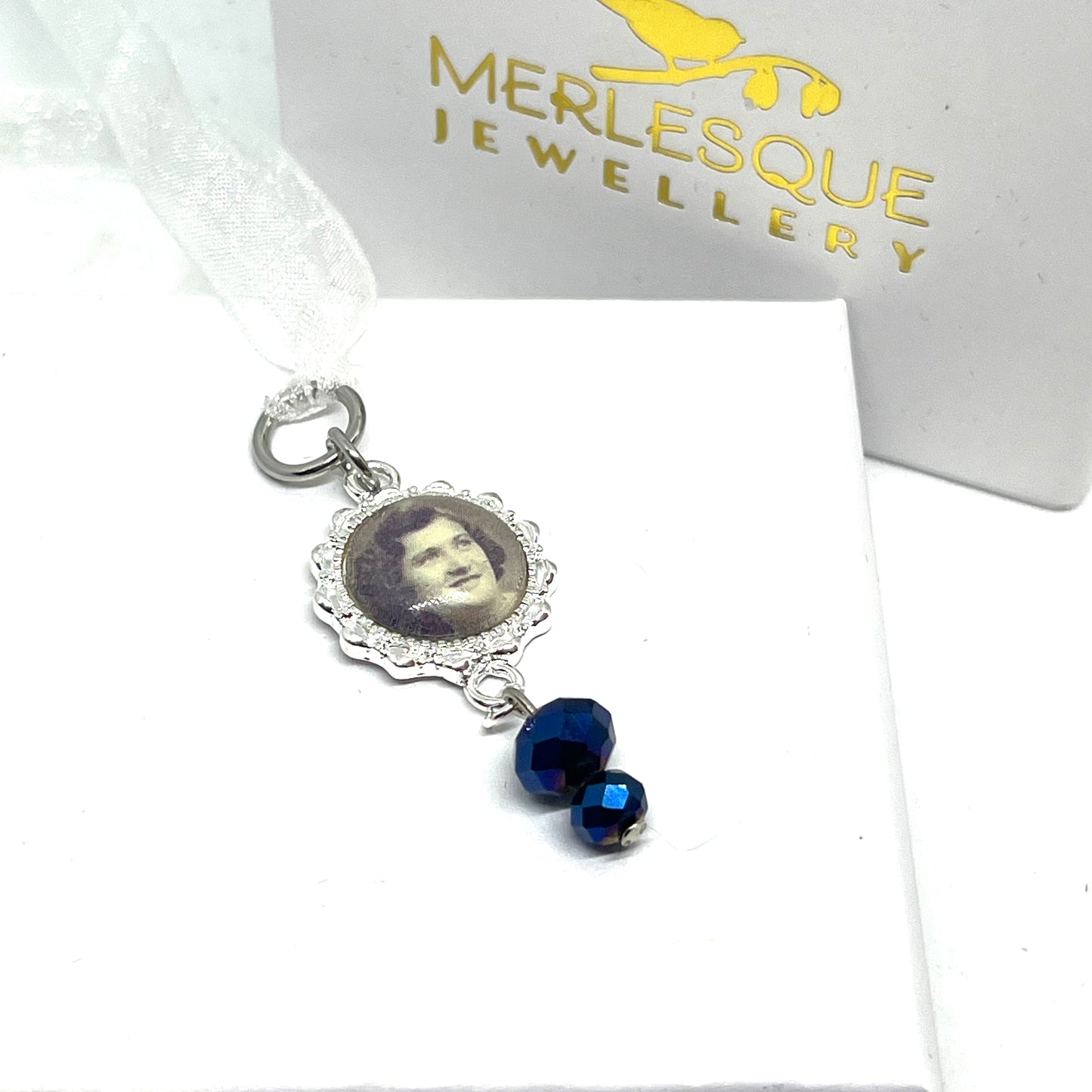 Silver seting with a photo set in it with blue glass beads.