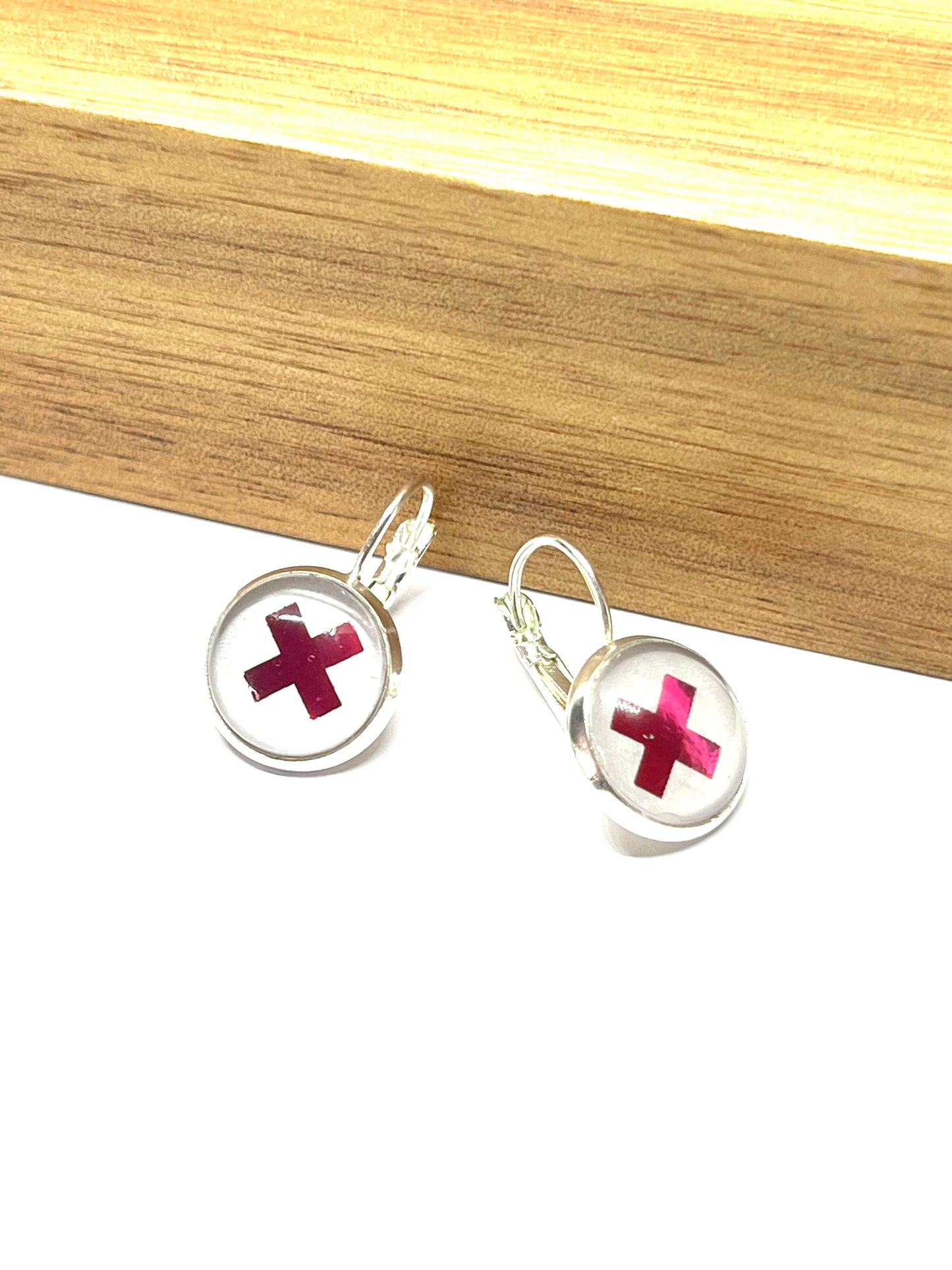 Hot pink kiss glass dome earrings on a dove grey background