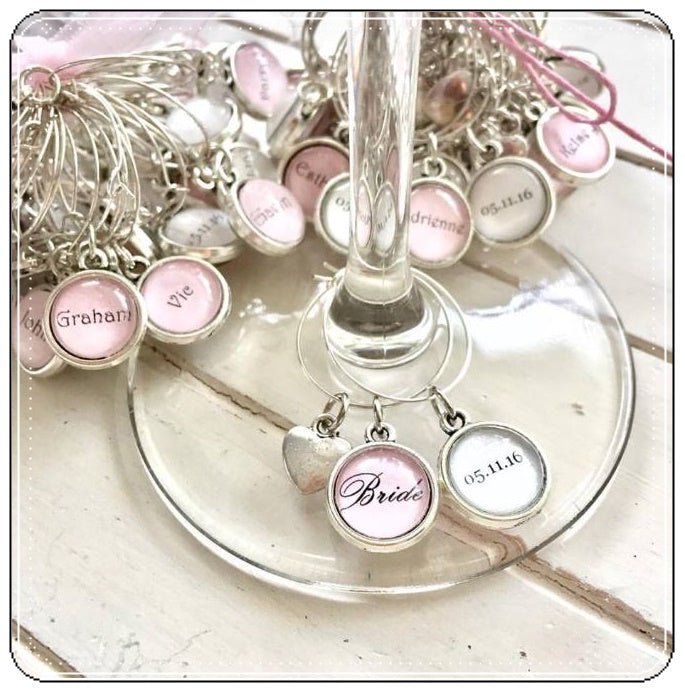 Pink and white bride wine glass charms with a heart.