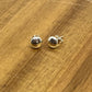 Sterling silver 6.6mm  flat head studs displayed on wood.