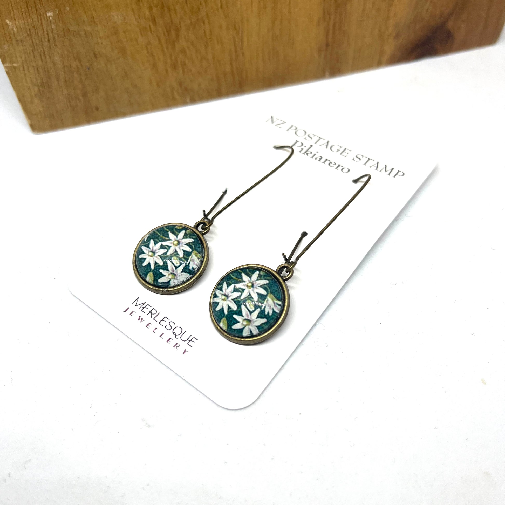 Pikiarero ( Clematis) flower postage stamp image  set on a silver 16mm glass dome setting with nickel free long hooks.