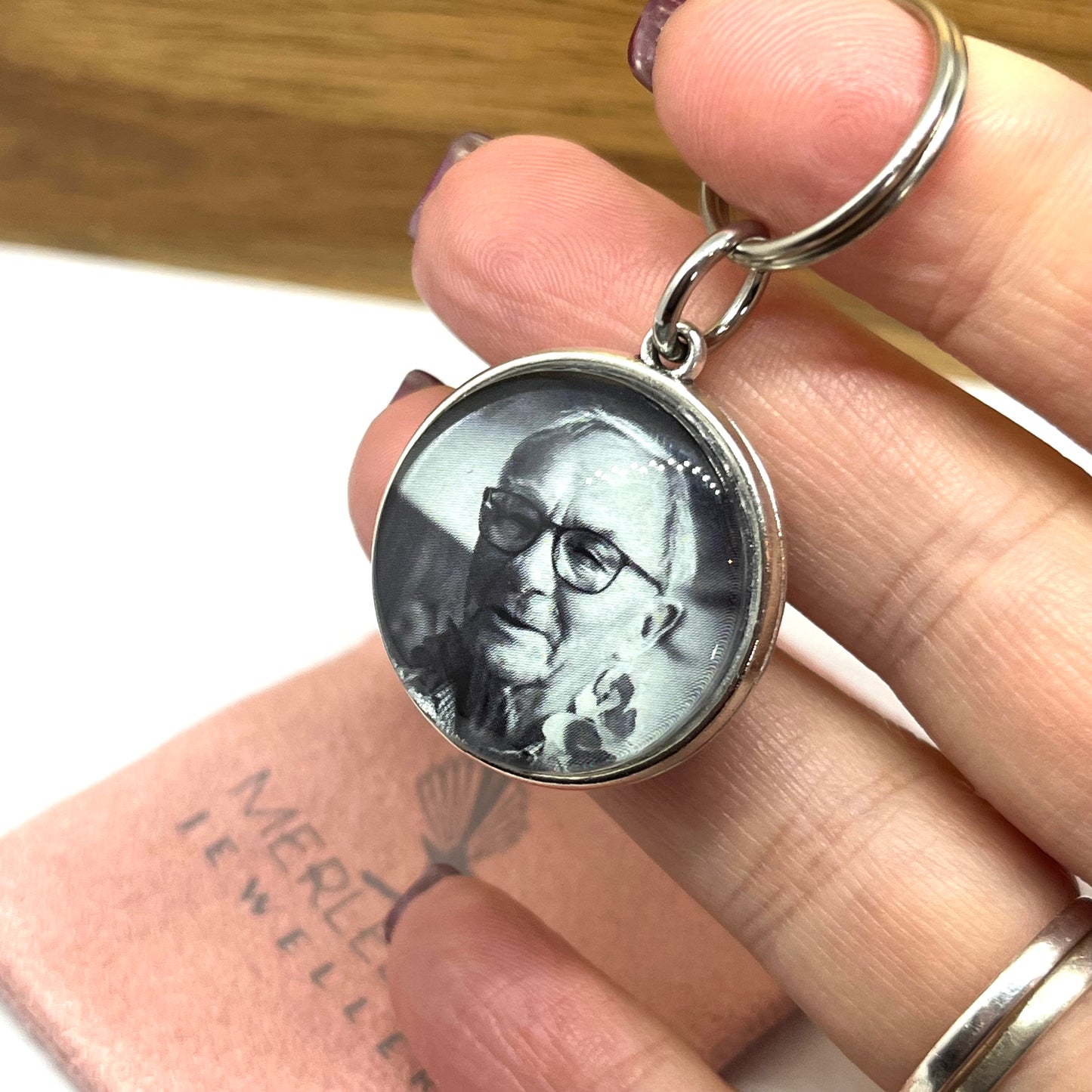 Photo of a man in a silver keyring.