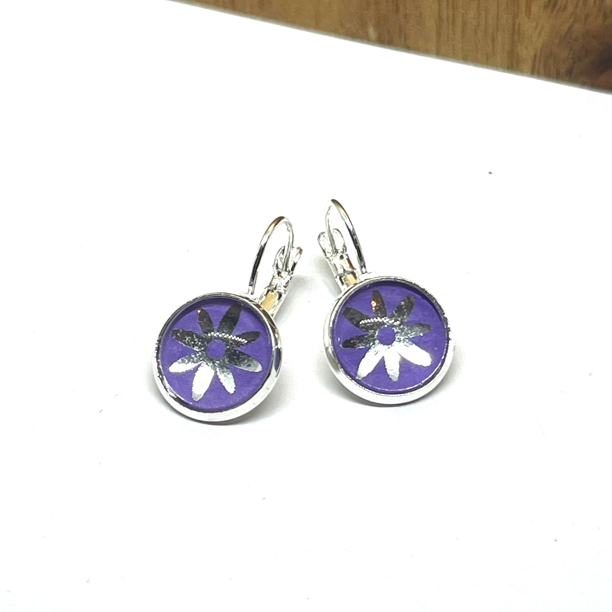 Silver daisy on purple glass dome earrings