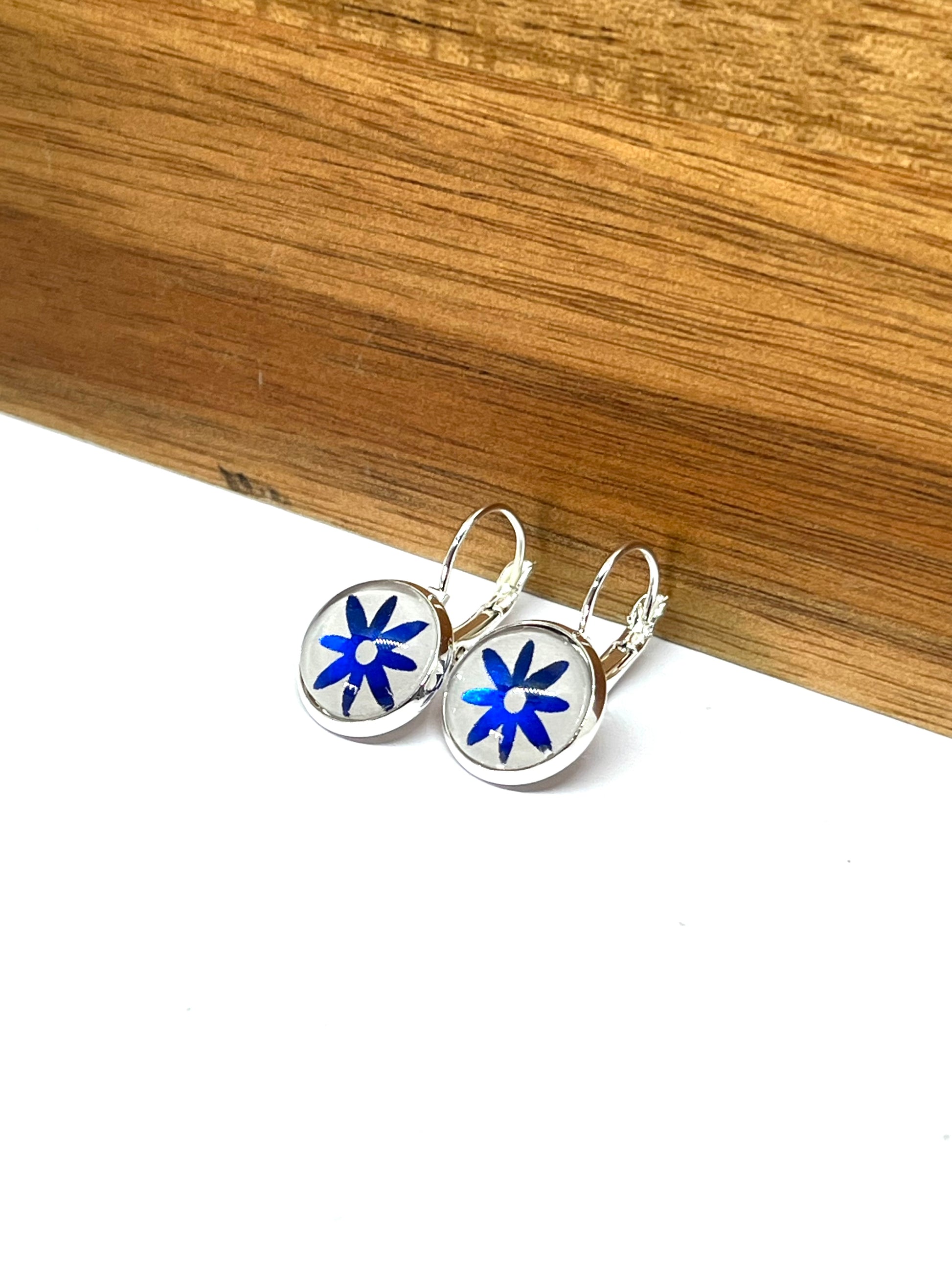 Sapphire blue daisy on a dove grey background glass dome earrings