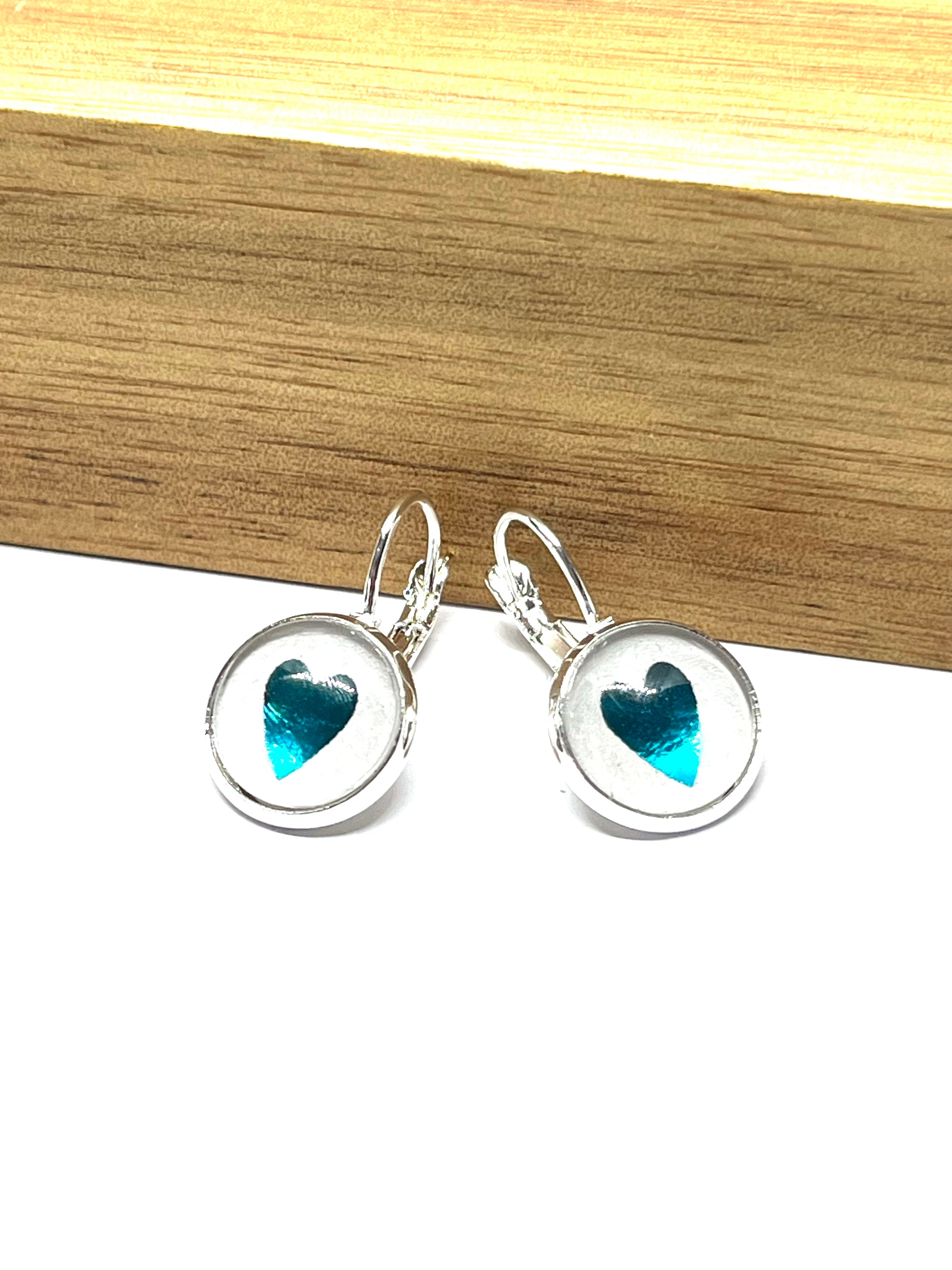Metallic Aqua blue heart glass dome earrings in a silver setting