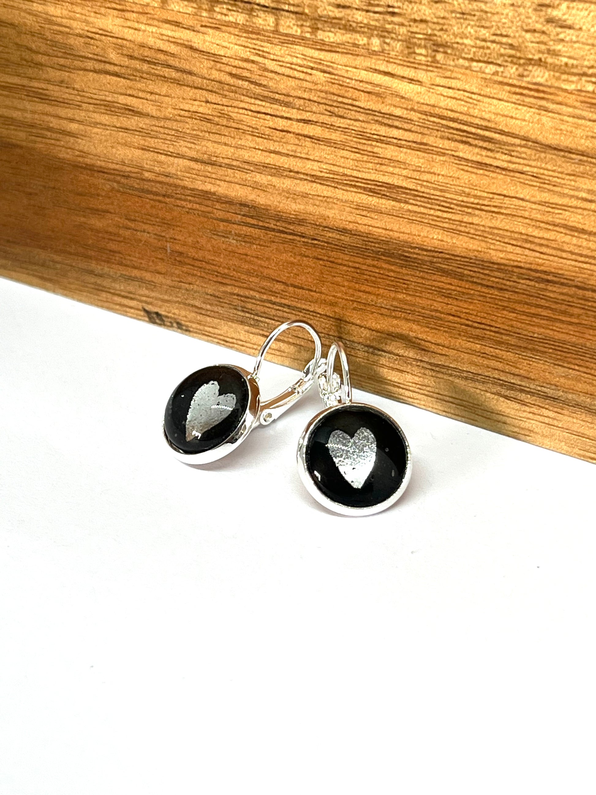 silver metallic hearts on a black background glass dome earrings