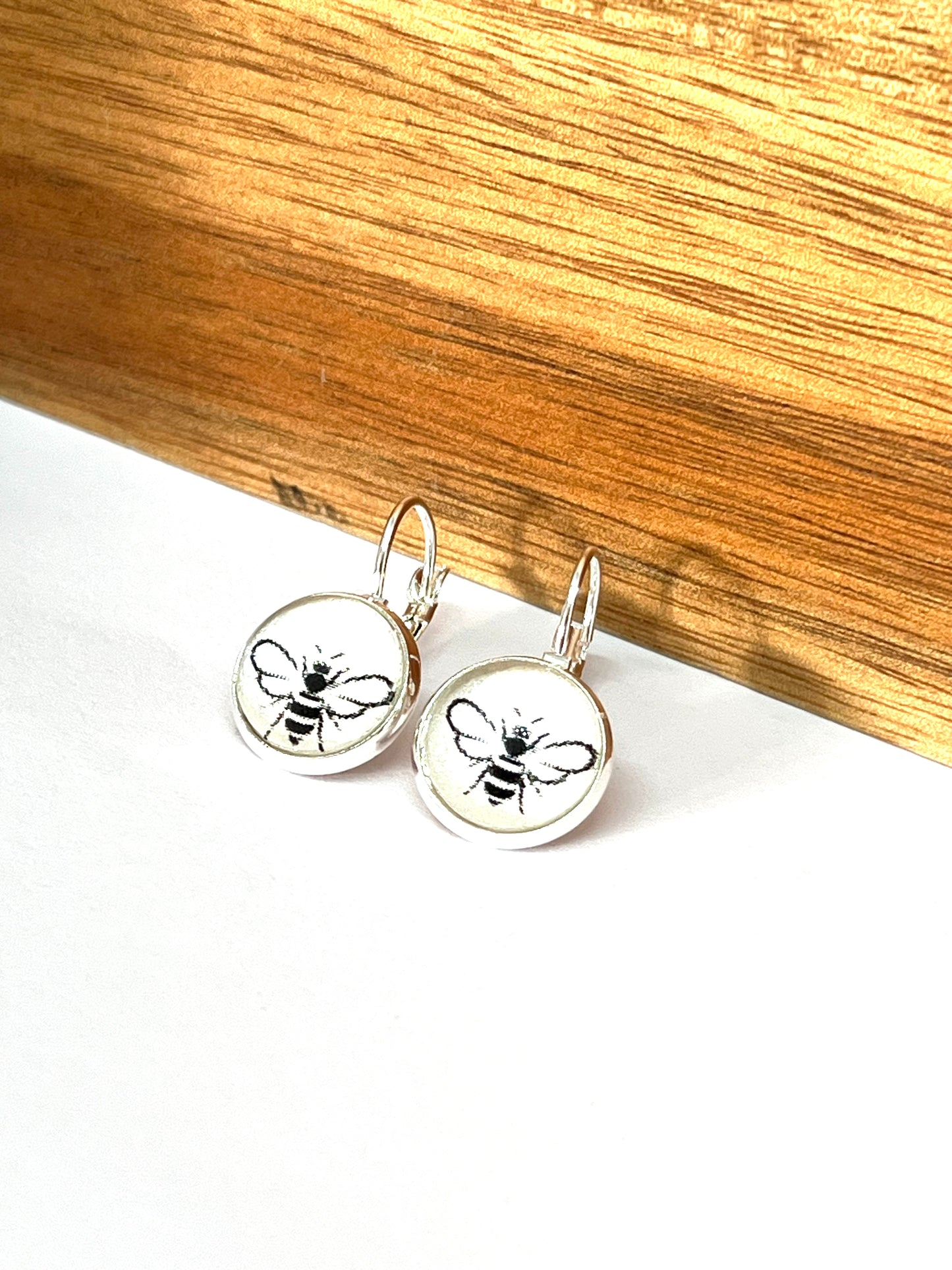 Black bees on a pearl white background glass dome earrings