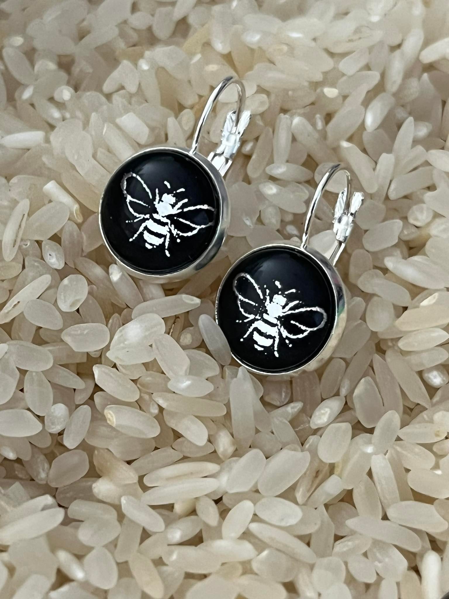silver bee on a black backgrund glass dome earrings