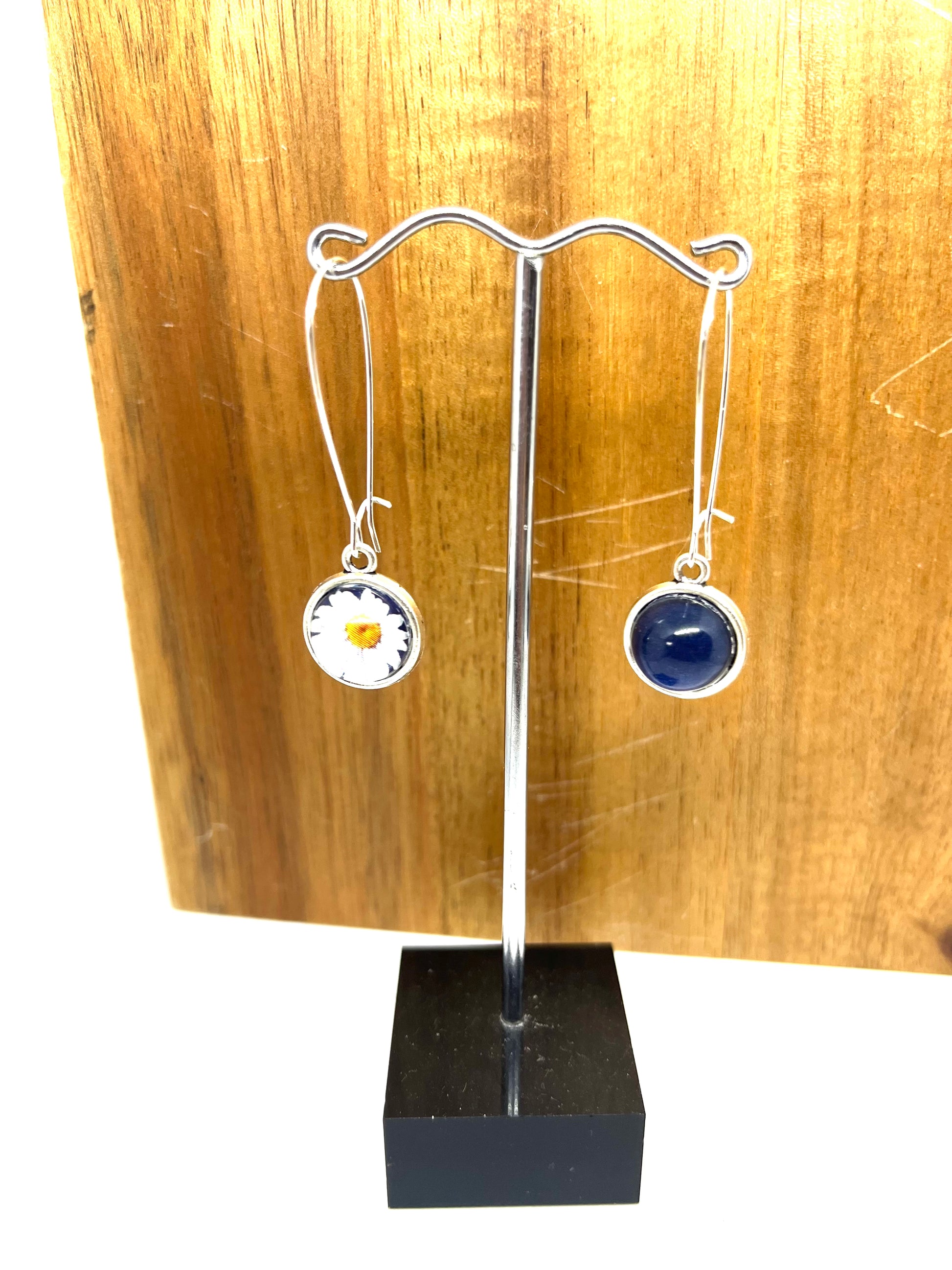 Double sided glass dome earrings with navy on one side and a white daisy with navy background on the othe
