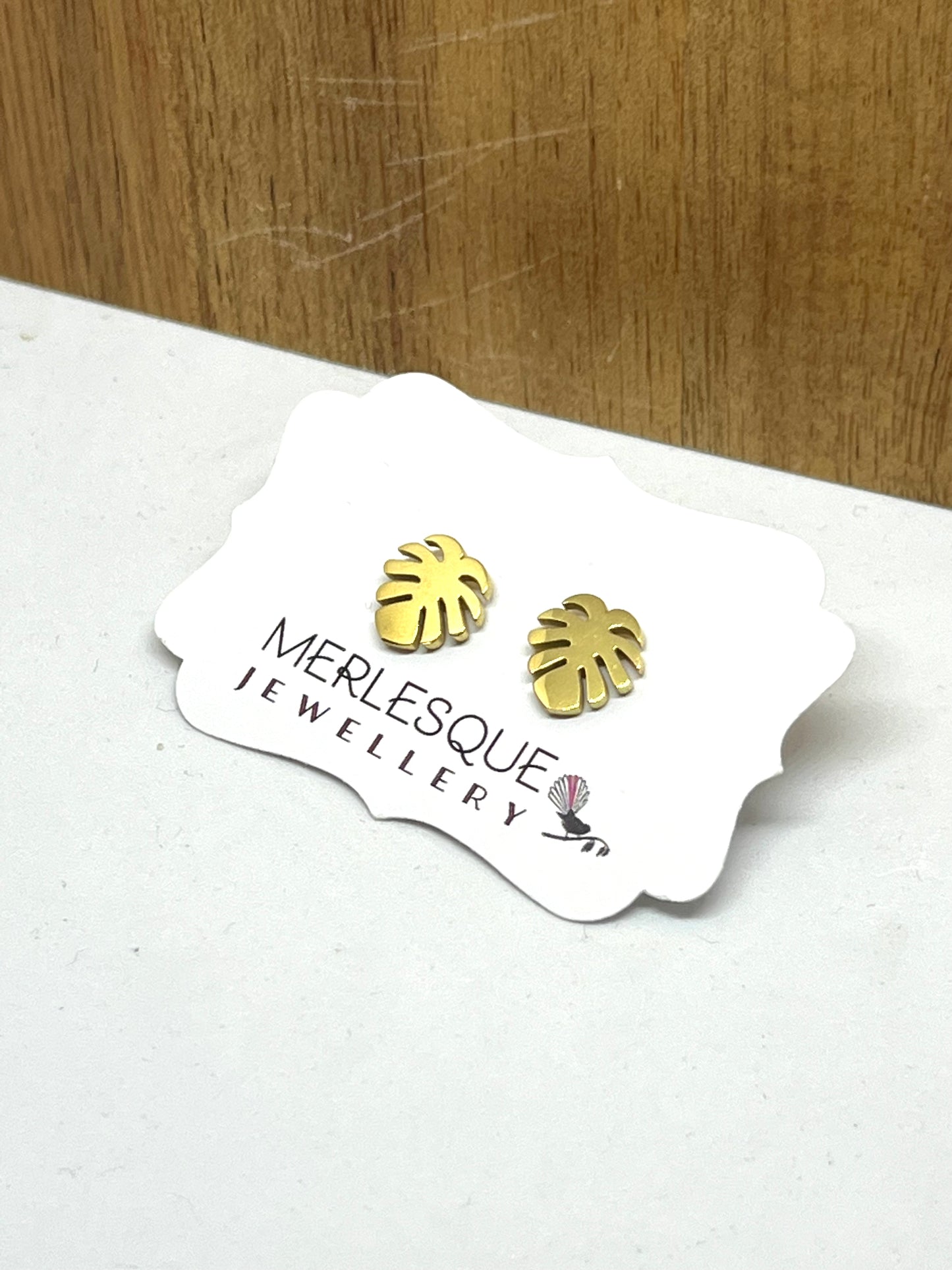 Stainless steel gold monstera leaf studs.
