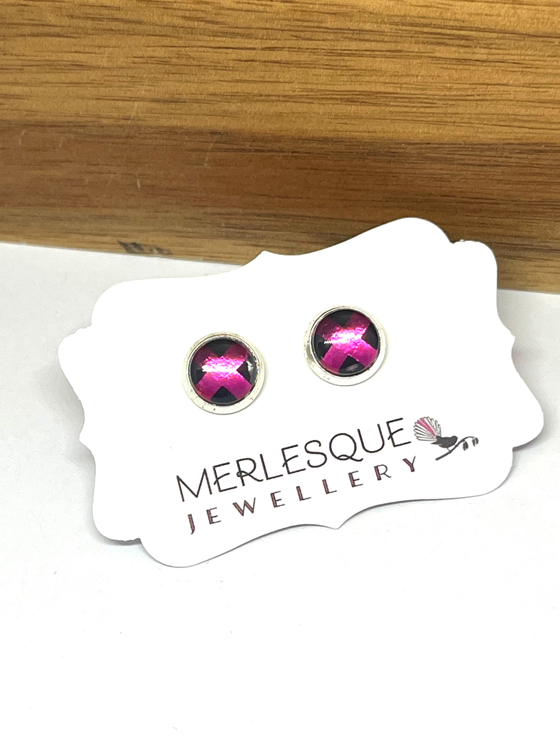 Hot pink kiss glass dome studs on a black background